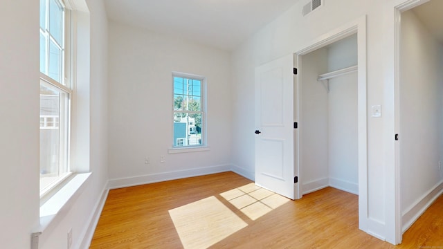 unfurnished bedroom with light wood-type flooring and a closet