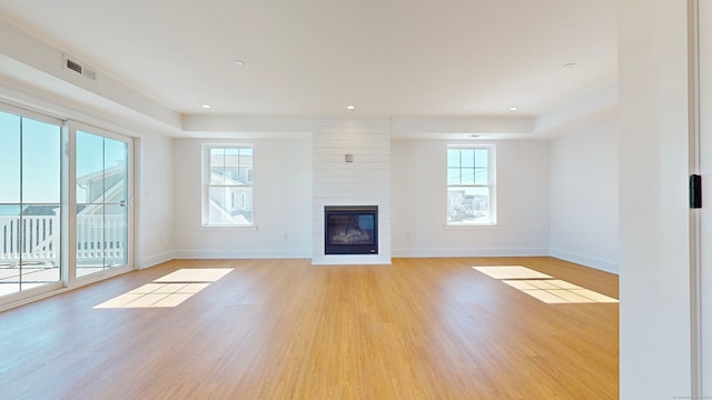 unfurnished living room with light hardwood / wood-style floors and a large fireplace