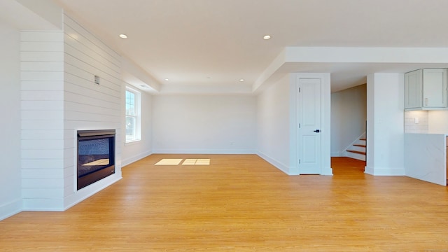 unfurnished living room with light wood-type flooring and a fireplace