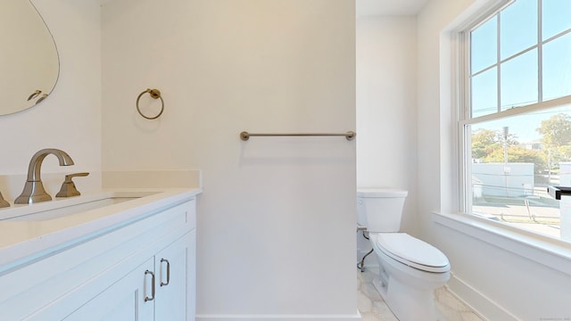 bathroom featuring vanity, plenty of natural light, and toilet