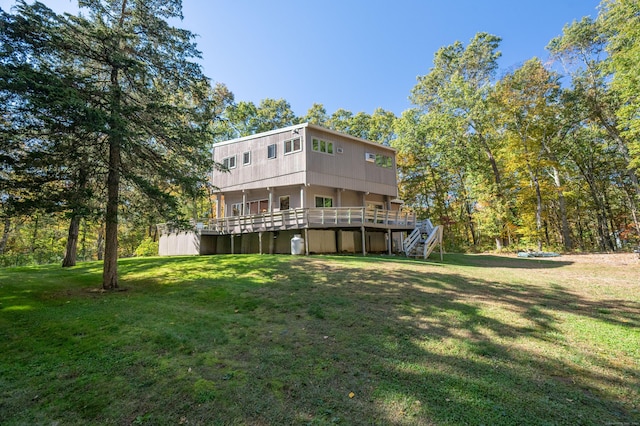 rear view of property with a deck and a lawn