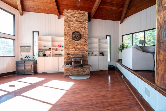 unfurnished living room featuring beam ceiling, a wood stove, wooden ceiling, a wall mounted AC, and wood-type flooring