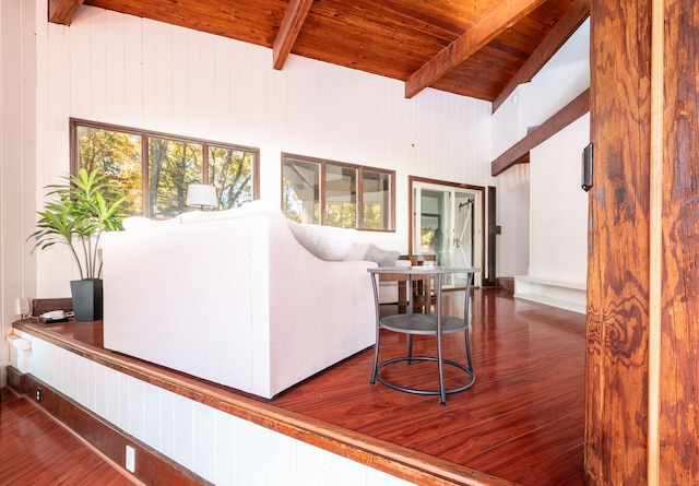 living room with vaulted ceiling with beams, wood walls, wooden ceiling, and hardwood / wood-style flooring