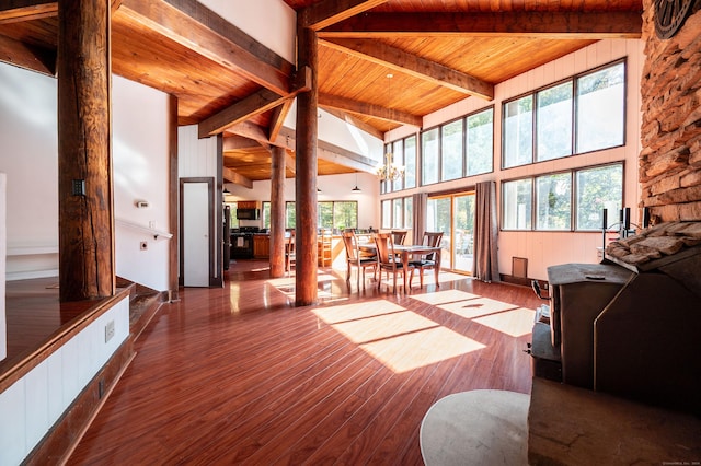 living room with a healthy amount of sunlight, dark hardwood / wood-style flooring, and beam ceiling