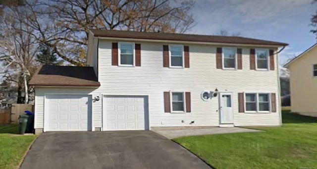 view of front of property with a front yard and a garage