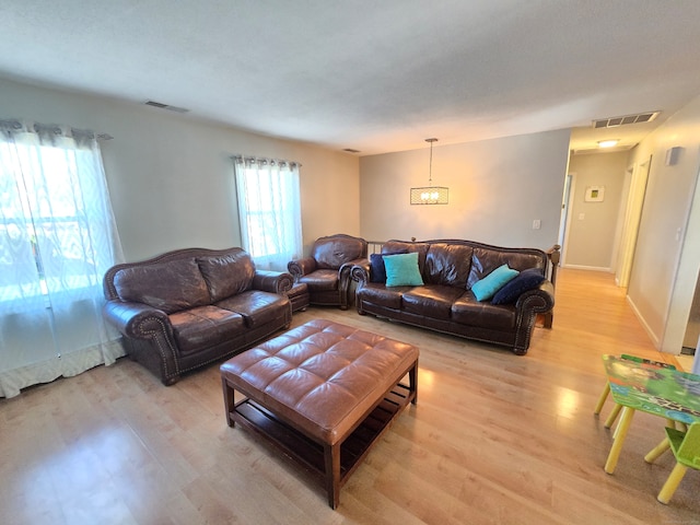 living room featuring light hardwood / wood-style flooring and a notable chandelier