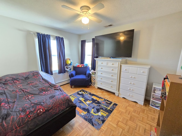 bedroom with baseboard heating, a textured ceiling, light parquet flooring, and ceiling fan