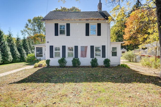 colonial-style house featuring a front yard