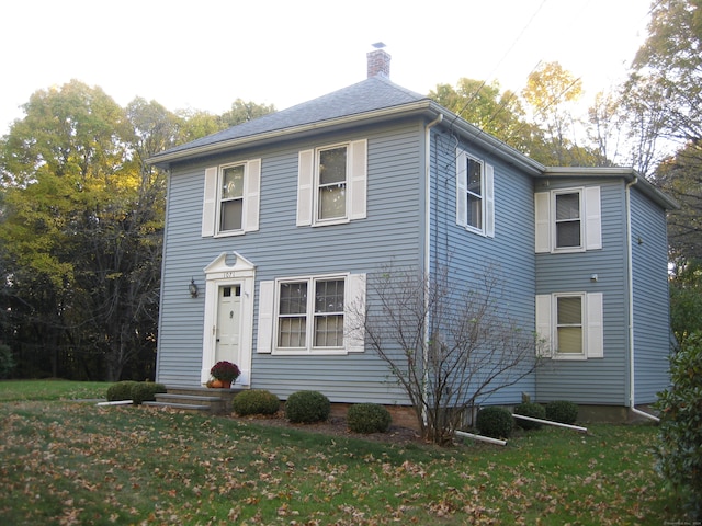 colonial house featuring a front lawn