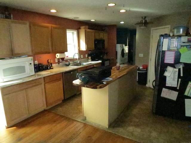 kitchen with black fridge, light hardwood / wood-style flooring, stainless steel dishwasher, washing machine and dryer, and a kitchen island