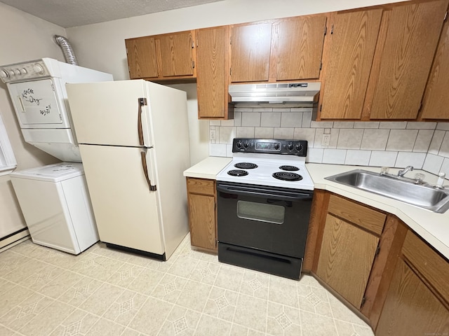 kitchen featuring under cabinet range hood, range with electric cooktop, a sink, light countertops, and freestanding refrigerator