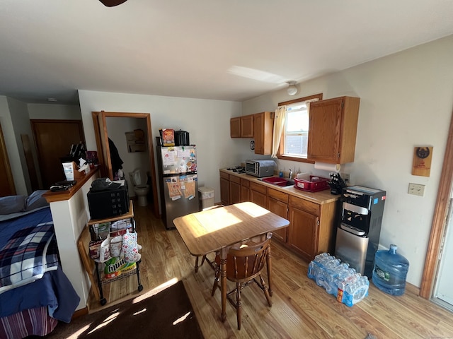 kitchen featuring sink, stainless steel refrigerator, and light hardwood / wood-style floors