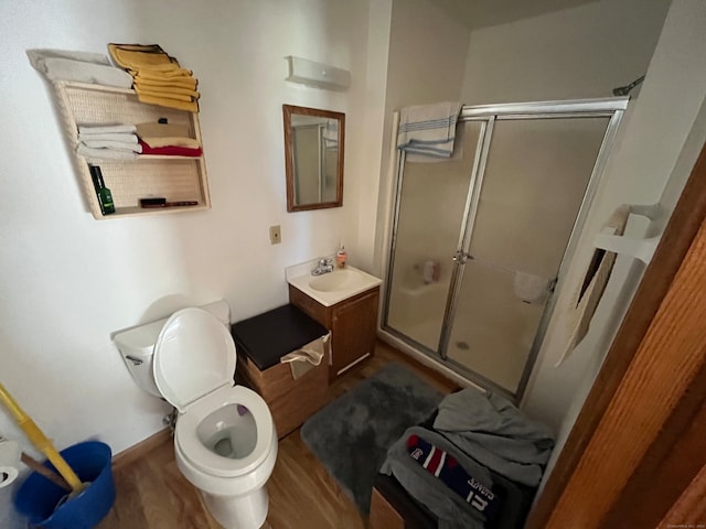 bathroom with toilet, vanity, hardwood / wood-style flooring, and a shower with shower door