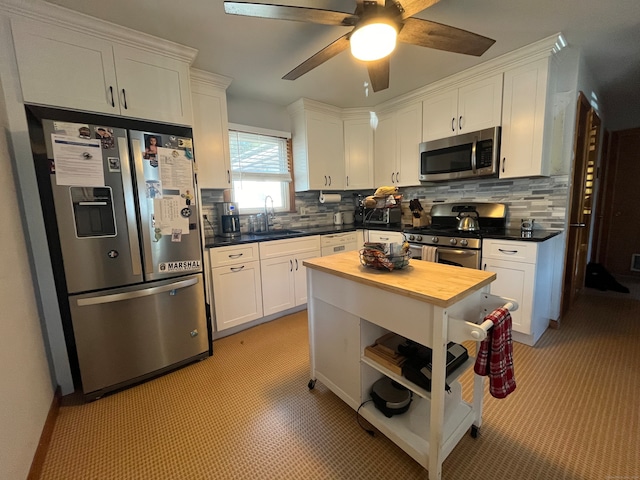 kitchen featuring white cabinetry, appliances with stainless steel finishes, sink, and backsplash