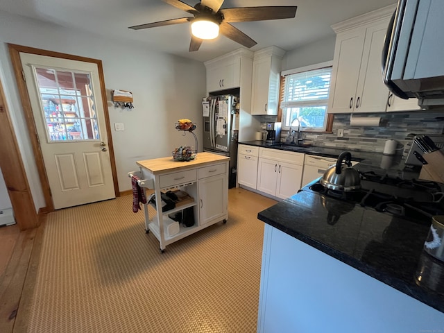 kitchen featuring white cabinetry, sink, ceiling fan, backsplash, and stainless steel fridge