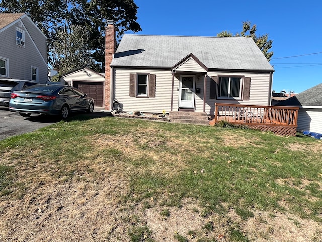 view of front of house with an outbuilding, a garage, and a front lawn