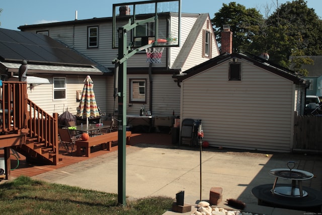 rear view of house featuring a wooden deck and a patio