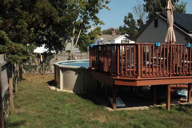 view of swimming pool with a lawn and a wooden deck