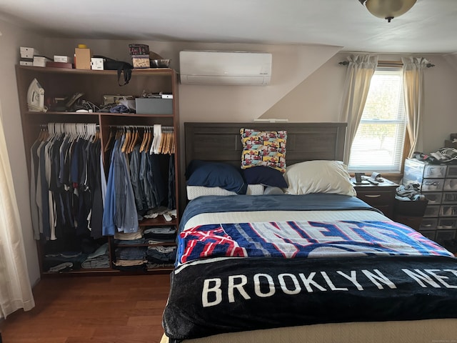 bedroom featuring hardwood / wood-style floors, a wall unit AC, and a closet