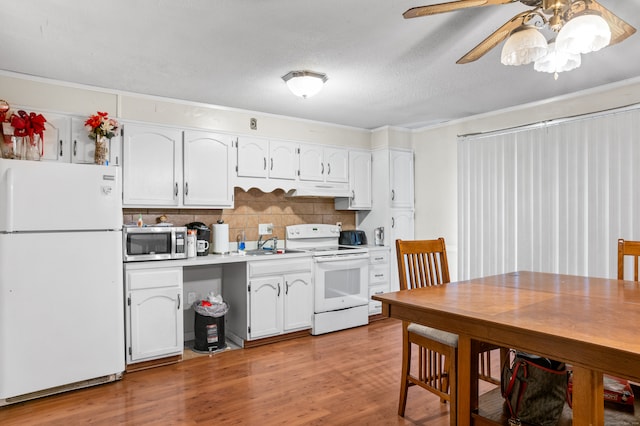 kitchen featuring white appliances, backsplash, white cabinetry, and light wood-type flooring