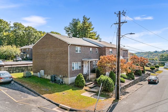 222 Judith Ln Unit 5, Waterbury, CT 06704 - traditional-style house with brick siding, roof mounted solar panels, and a front yard