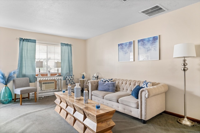 living room with a wall mounted air conditioner, carpet flooring, a textured ceiling, and visible vents