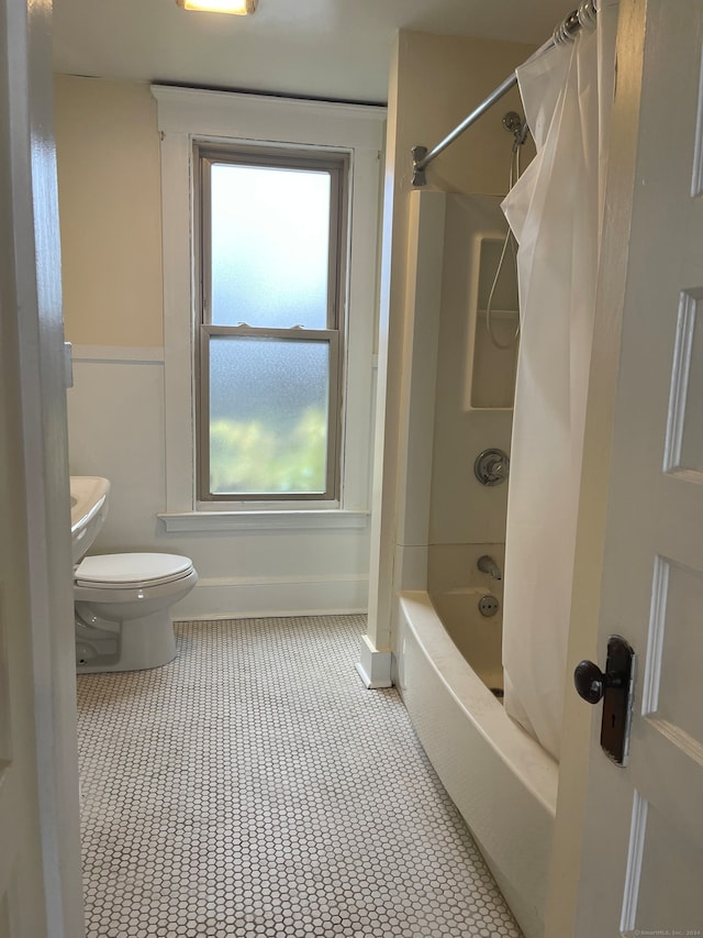 bathroom featuring tile patterned flooring, toilet, and shower / bath combo with shower curtain