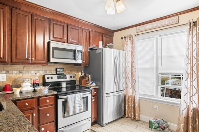 kitchen with appliances with stainless steel finishes, backsplash, dark stone counters, ceiling fan, and crown molding