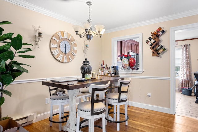 bar featuring a baseboard heating unit, crown molding, hanging light fixtures, light hardwood / wood-style floors, and a chandelier