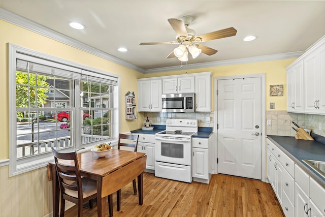 kitchen featuring white range with electric cooktop, decorative backsplash, light hardwood / wood-style floors, and white cabinetry