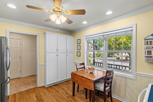 dining area with light wood-type flooring, ceiling fan, and ornamental molding