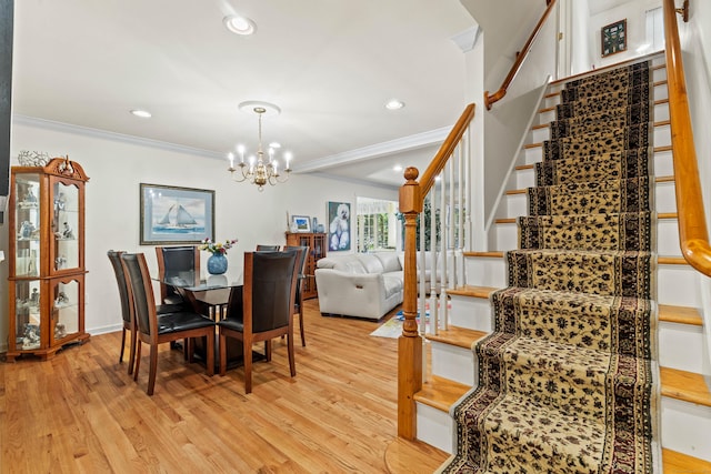 dining area featuring crown molding, a chandelier, and light hardwood / wood-style floors