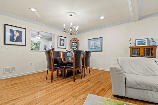 dining area with ceiling fan with notable chandelier, light wood-type flooring, and ornamental molding