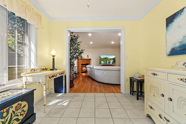 hall featuring light tile patterned floors and ornamental molding