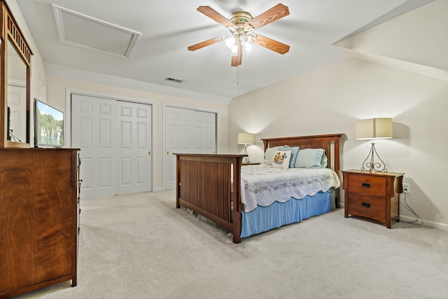 bedroom featuring light carpet, ceiling fan, and multiple closets