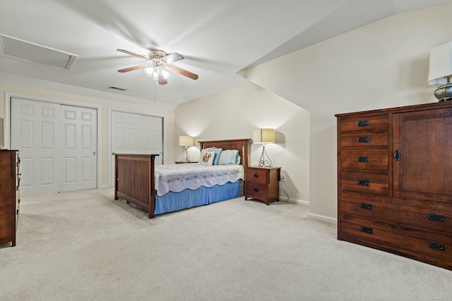 carpeted bedroom featuring ceiling fan, lofted ceiling, and multiple closets