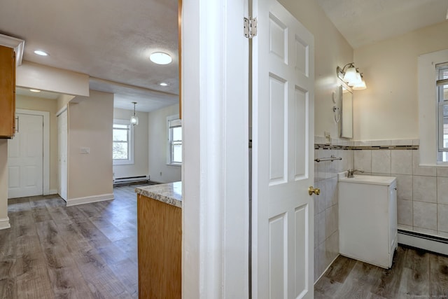 bathroom with vanity, baseboard heating, and wood-type flooring