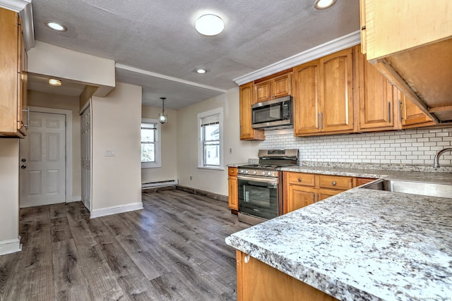 kitchen with appliances with stainless steel finishes, a textured ceiling, baseboard heating, pendant lighting, and backsplash