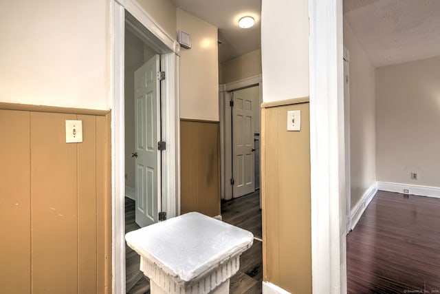 corridor featuring dark hardwood / wood-style floors and a textured ceiling