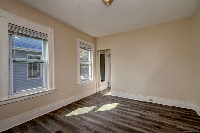 unfurnished room with a textured ceiling and dark hardwood / wood-style floors