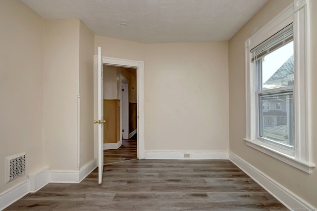 spare room with hardwood / wood-style flooring and a textured ceiling