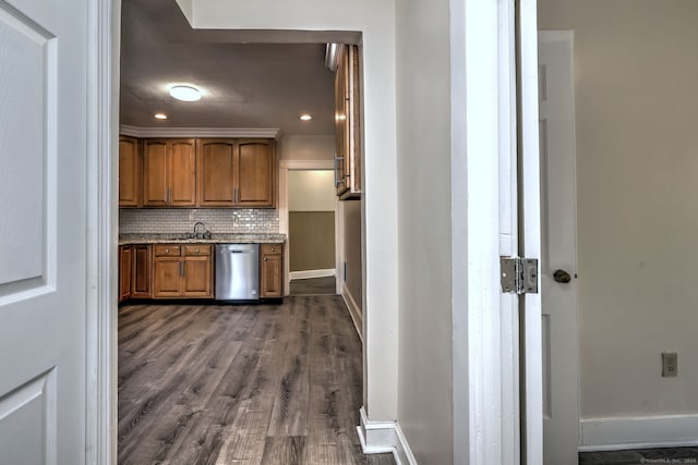 kitchen with stainless steel dishwasher, stone countertops, dark hardwood / wood-style flooring, sink, and tasteful backsplash