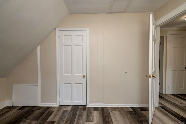 bonus room featuring dark wood-type flooring and vaulted ceiling