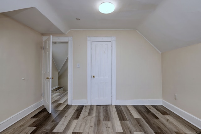 additional living space with vaulted ceiling and wood-type flooring