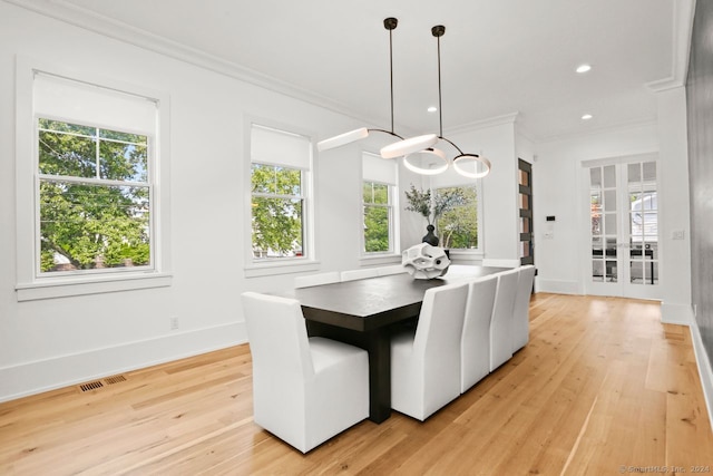 dining room featuring ornamental molding and light wood-type flooring