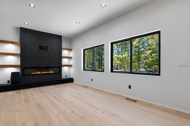 unfurnished living room featuring a fireplace and light hardwood / wood-style floors