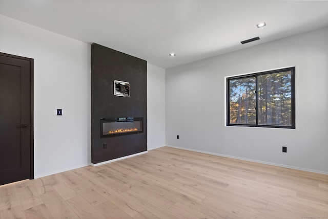 unfurnished room with light hardwood / wood-style floors and a fireplace