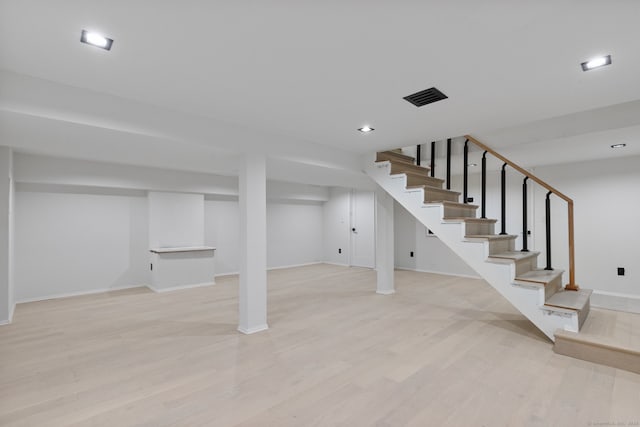 basement with light hardwood / wood-style flooring