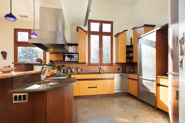 kitchen with range hood, decorative light fixtures, sink, decorative backsplash, and built in appliances