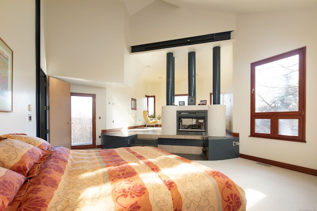 bedroom featuring high vaulted ceiling, carpet, and multiple windows